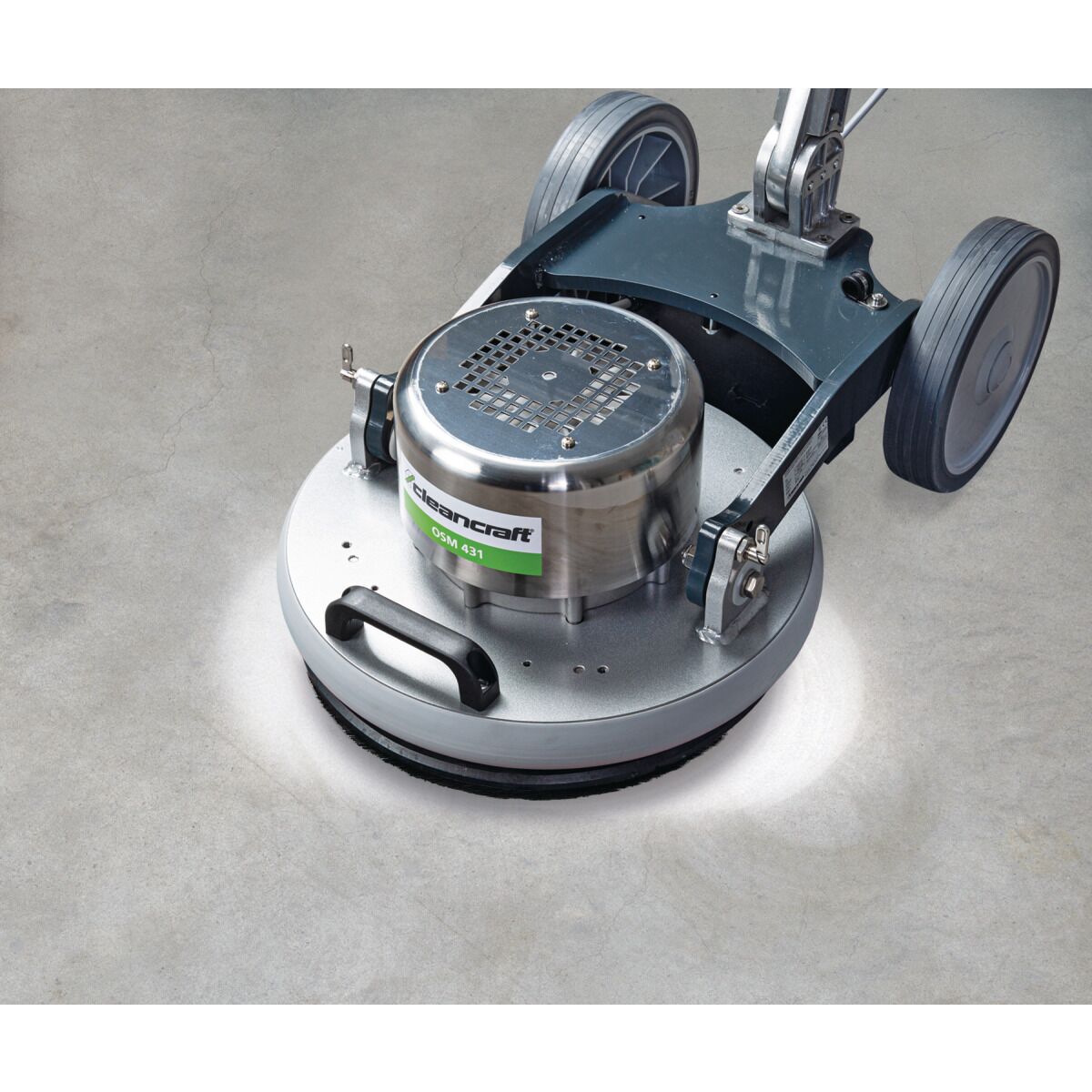 Bodenreinigungsmaschine auf hellem Betonboden, polierte Fläche deutlich sichtbar.