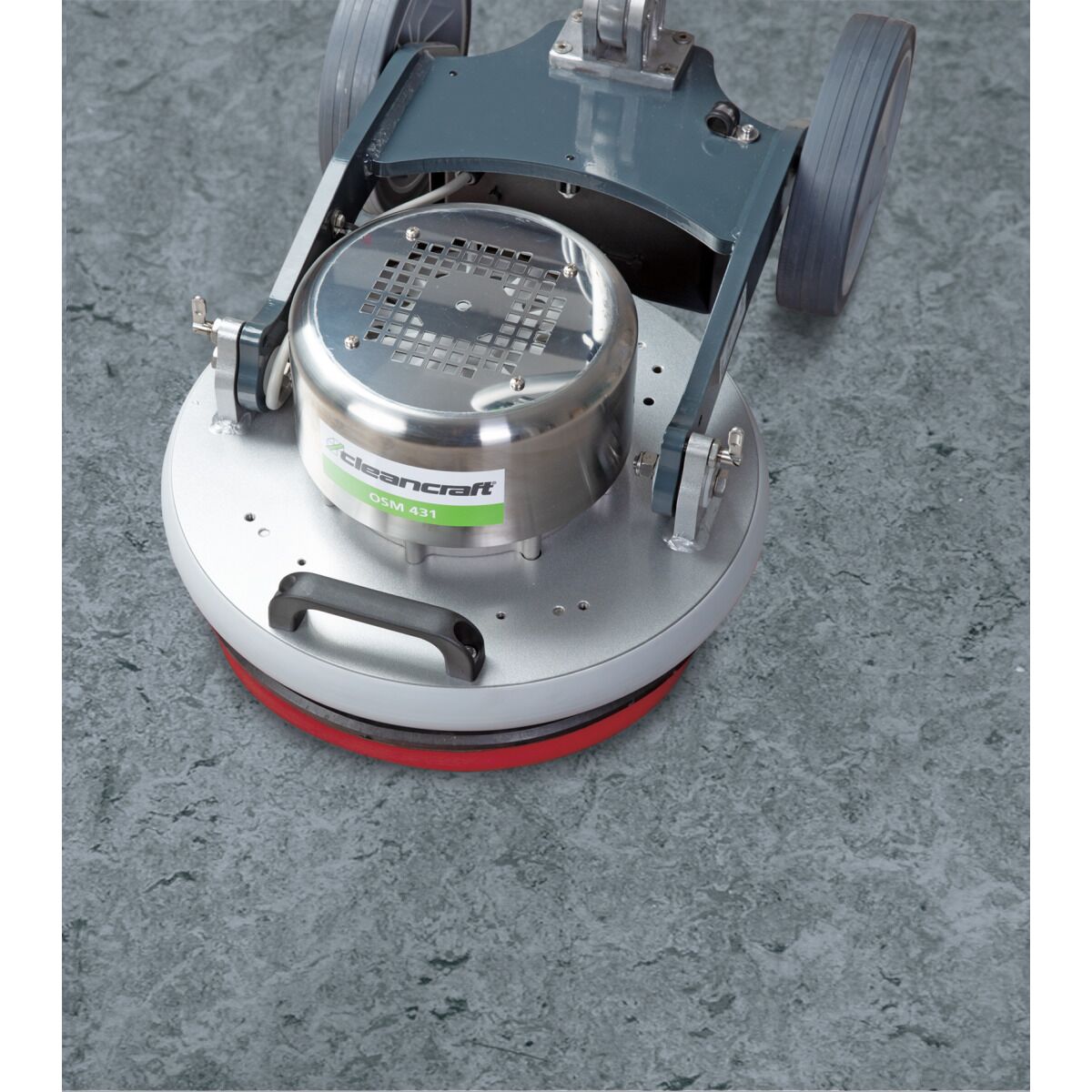 Bodenreinigungsmaschine reinigt glatten grauen Boden mit roter Bürste, gleichmäßiger Reinigungskreis.