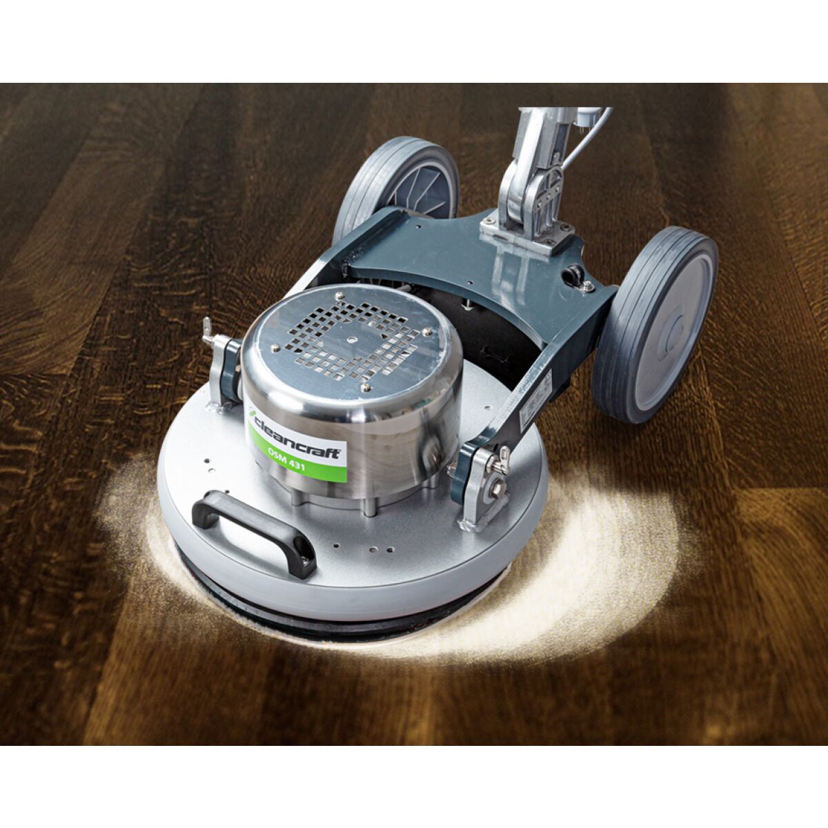 Bodenreinigungsmaschine poliert dunklen Holzfußboden, heller Reinigungskreis sichtbar.