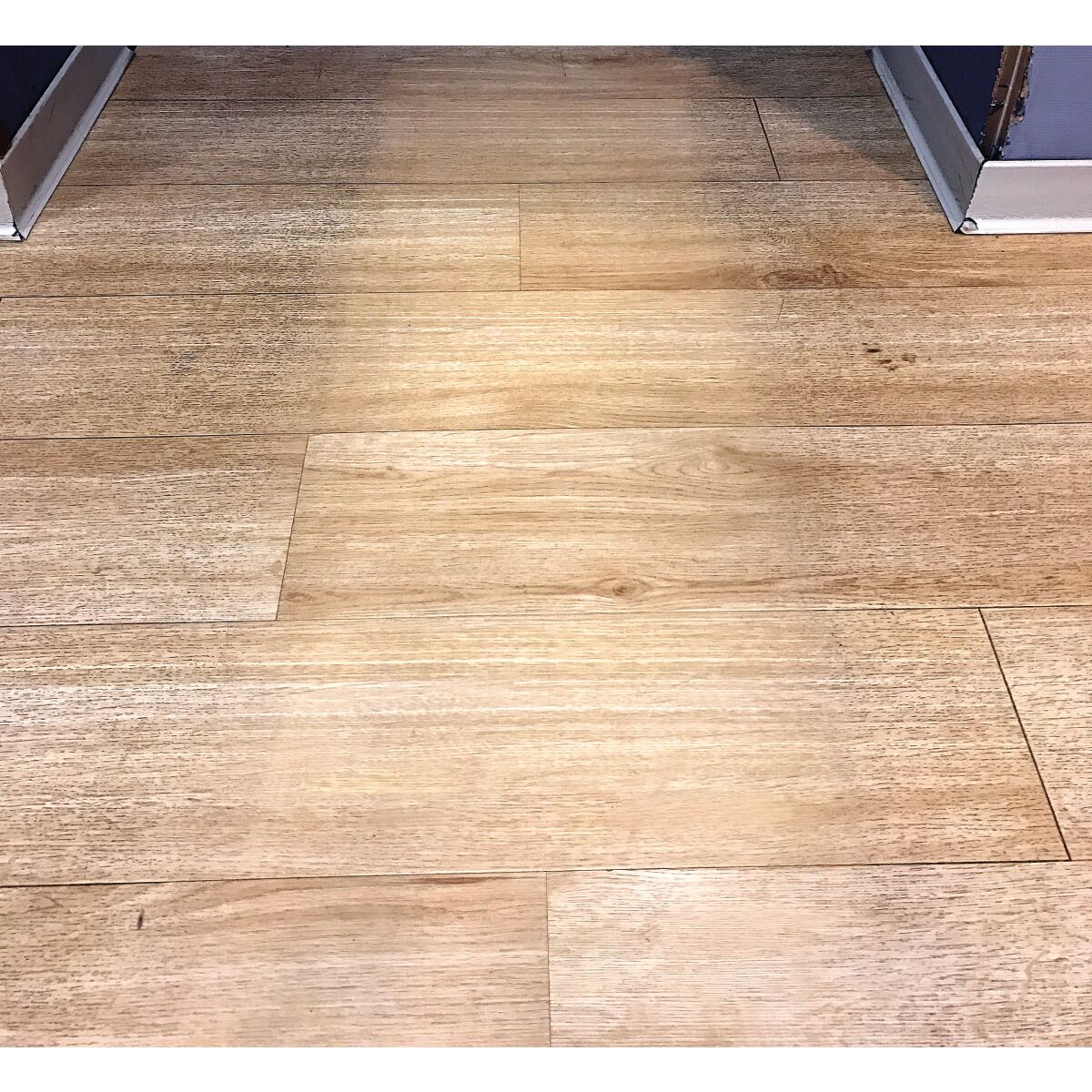 Gereinigter Holzfußboden mit deutlich sichtbarem Vorher-Nachher-Bereich.