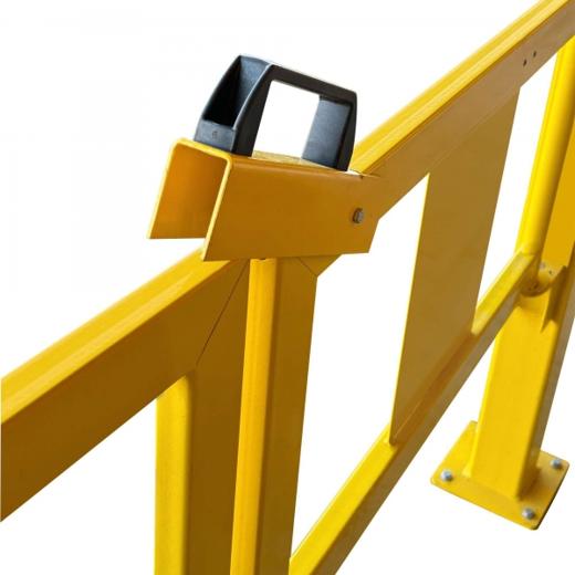 Gelbes Schutzgeländer mit schwarzem Griff an einer Verriegelungseinheit, montiert an Pfosten.