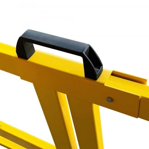 Nahaufnahme eines schwarzen Kunststoffgriffs auf einem gelben Schutzgeländer, freigestellt.