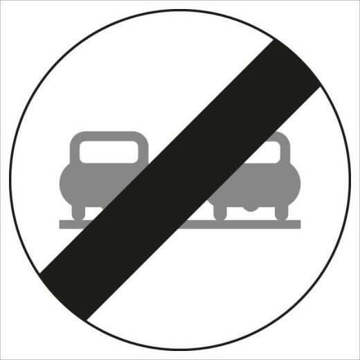 Verkehrszeichen: Weißer Kreis mit schwarzem Diagonalbalken, darin zwei graue Autos. Bedeutet: Ende des Überholverbots für Kraftfahrzeuge.