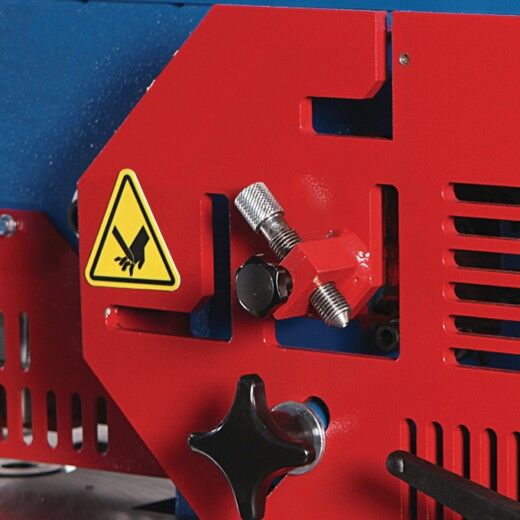 Detail der Maschinenfront mit Warnsymbol und verstellbarer Schraubmechanik.