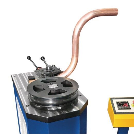 Rohrbiegemaschine mit eingespanntem Kupferrohr im Biegevorgang und Steuerpult.