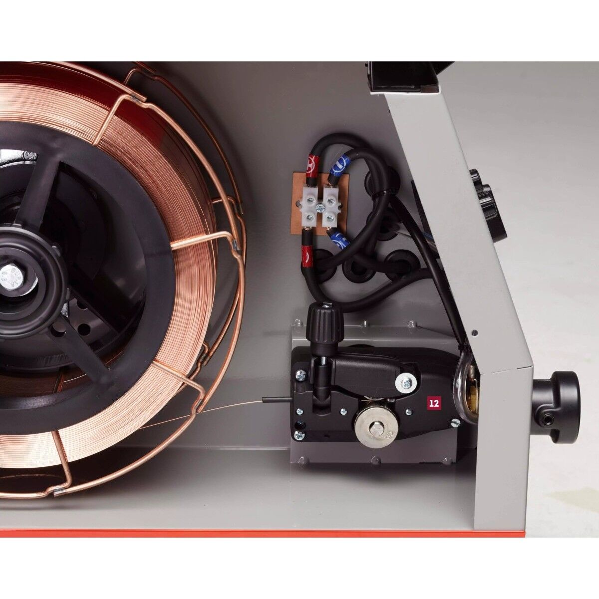 Detail innen: Drahtspule mit Kupferdraht links, rechts Drahtvorschub mit Vorschubrollen und Einstellknopf.