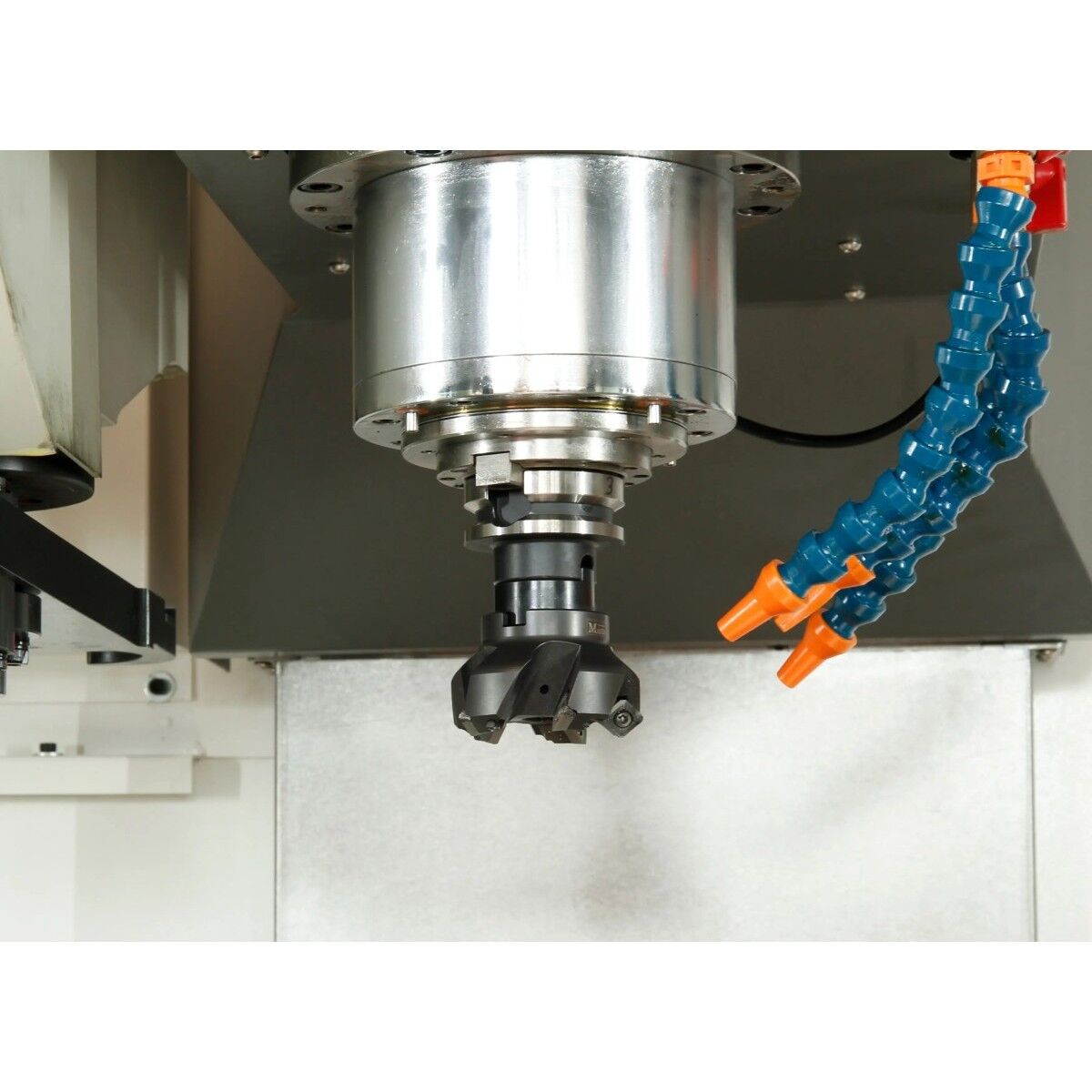 Detailansicht einer CNC-Frässpindel mit eingespanntem Fräswerkzeug und zwei Kühlmitteldüsen.