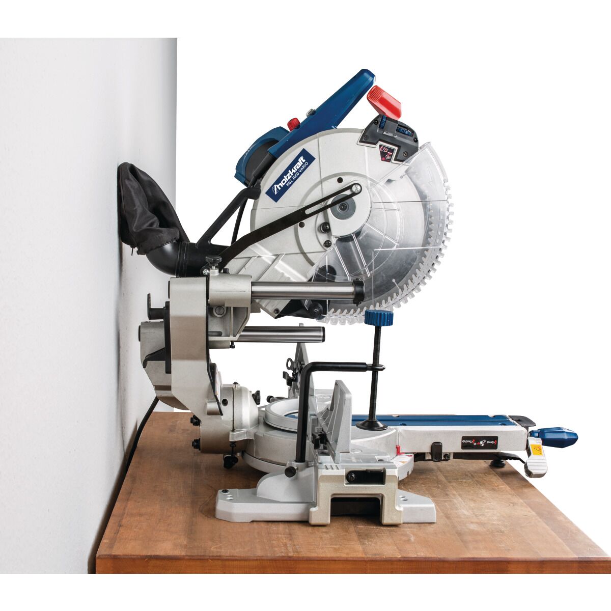 Gehrungssäge steht auf Werkbank direkt an Wand, Seitenansicht.