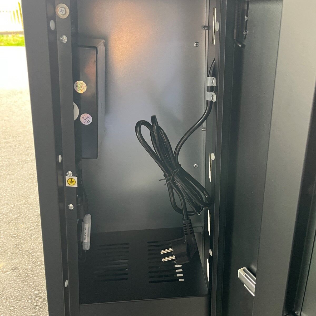 Nahaufnahme des Innenraums eines Heizgeräts mit Stromkabel und Bauteilen.