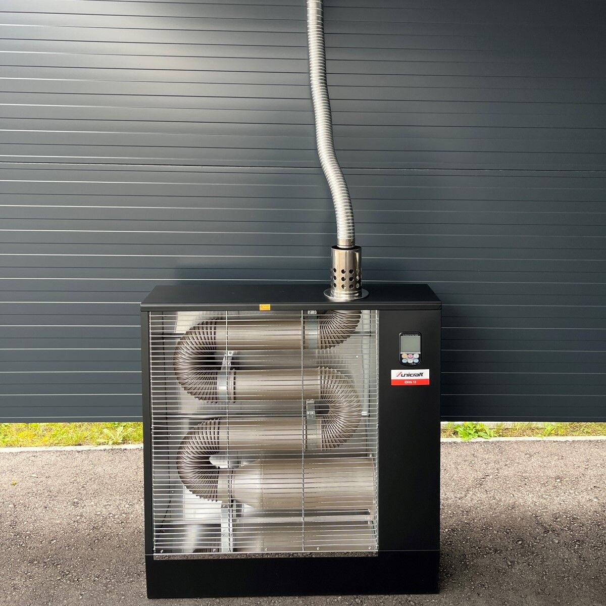 Heizgerät Unicraft IDHG 13 mit montiertem Abgasrohr auf Asphaltfläche.