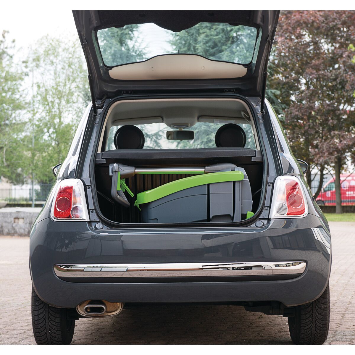 Zusammengeklappte Reinigungsmaschine im Kofferraum eines Autos, zeigt ihre kompakte Transportgröße.