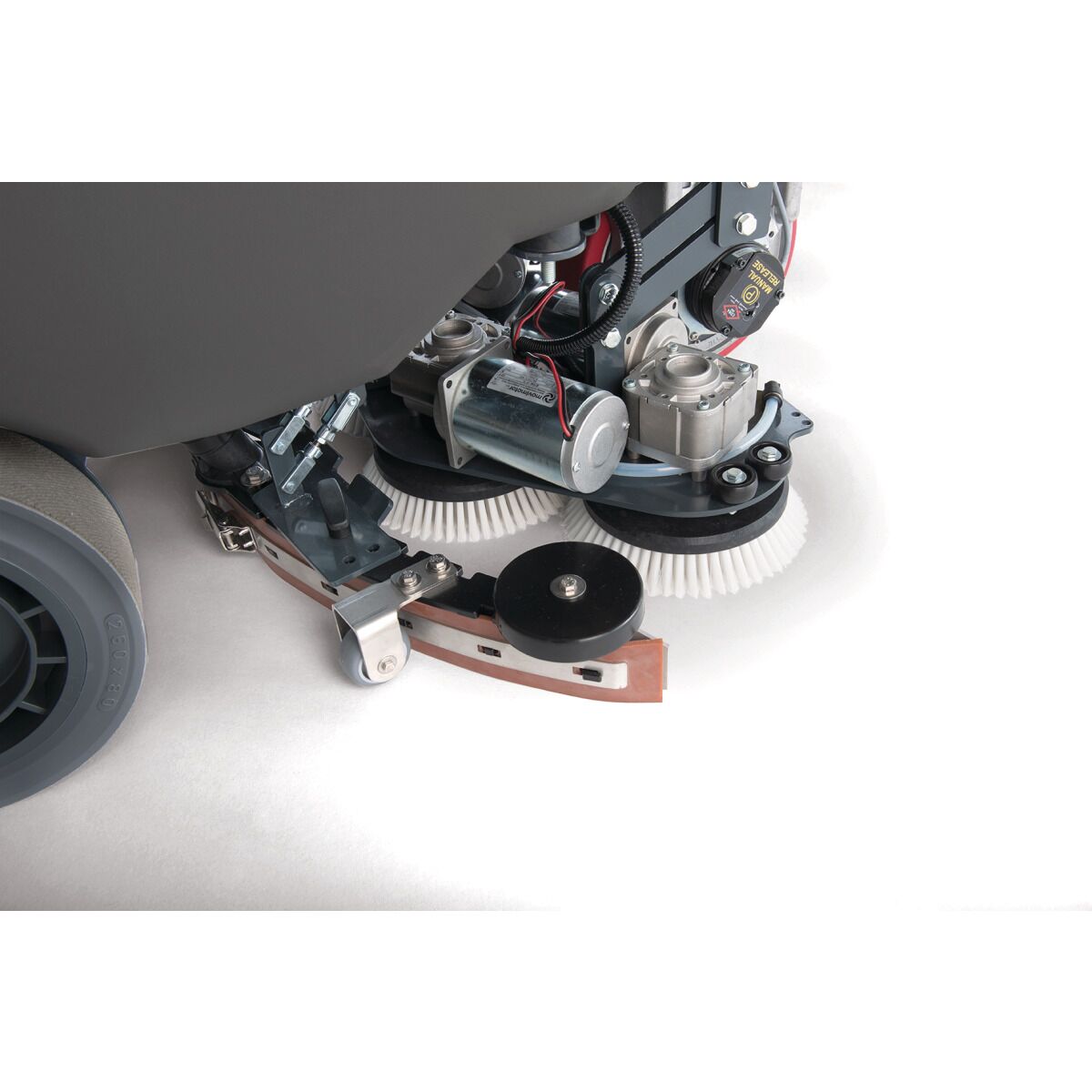 Nahaufnahme der Reinigungsbürsten, Motoren und Saugleiste unter der Aufsitz-Scheuersaugmaschine.