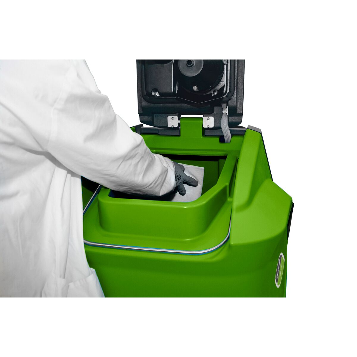 Person mit weißem Kittel legt ein Tuch in die Tanköffnung einer grünen Aufsitz-Scheuersaugmaschine.