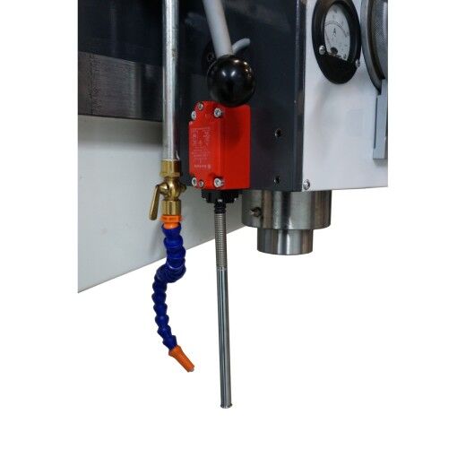 Nahaufnahme des Bohrkopfs mit Kühlmitteldüse, Schalthebel und Messuhr.