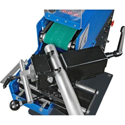 Schraubstock hält ein Rundrohr vor dem Schleifband der Bandschleifmaschine.