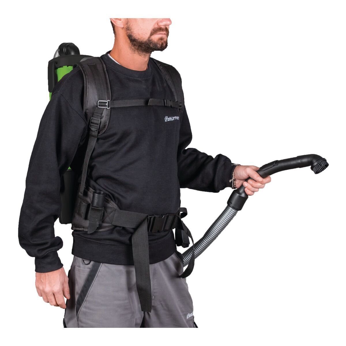 Person trägt Rucksackstaubsauger und hält den Saugschlauch in Arbeitsposition.