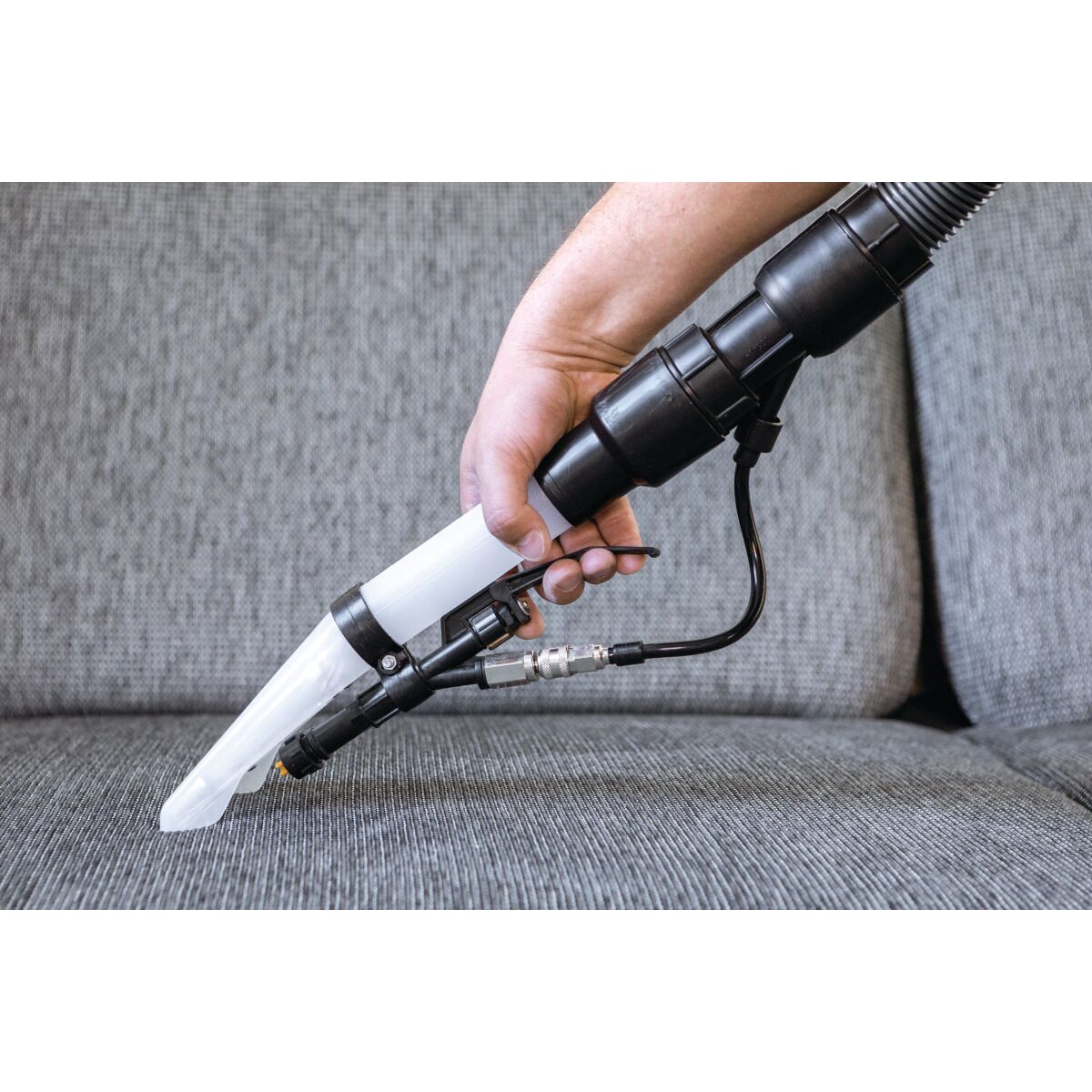 Polsterdüse des flexCAT 116 PD beim Reinigen einer Stoffcouch.