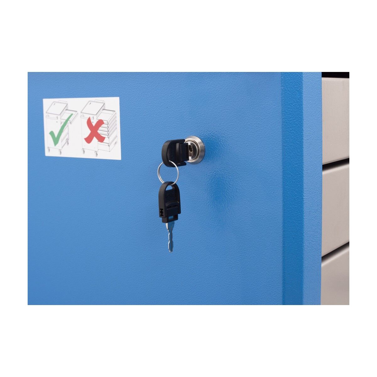 Nahaufnahme einer Schubladenschiene am Werkzeugwagen; links Seitenwand mit eingestecktem Schlüssel.