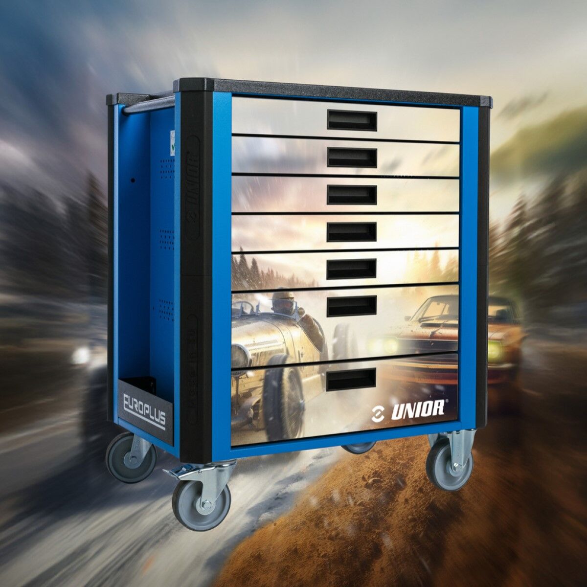 Werkzeugwagen mit sechs grauen Schubladen vor verschwommenem Hintergrund mit Rennfahrzeugen auf einer Straße.