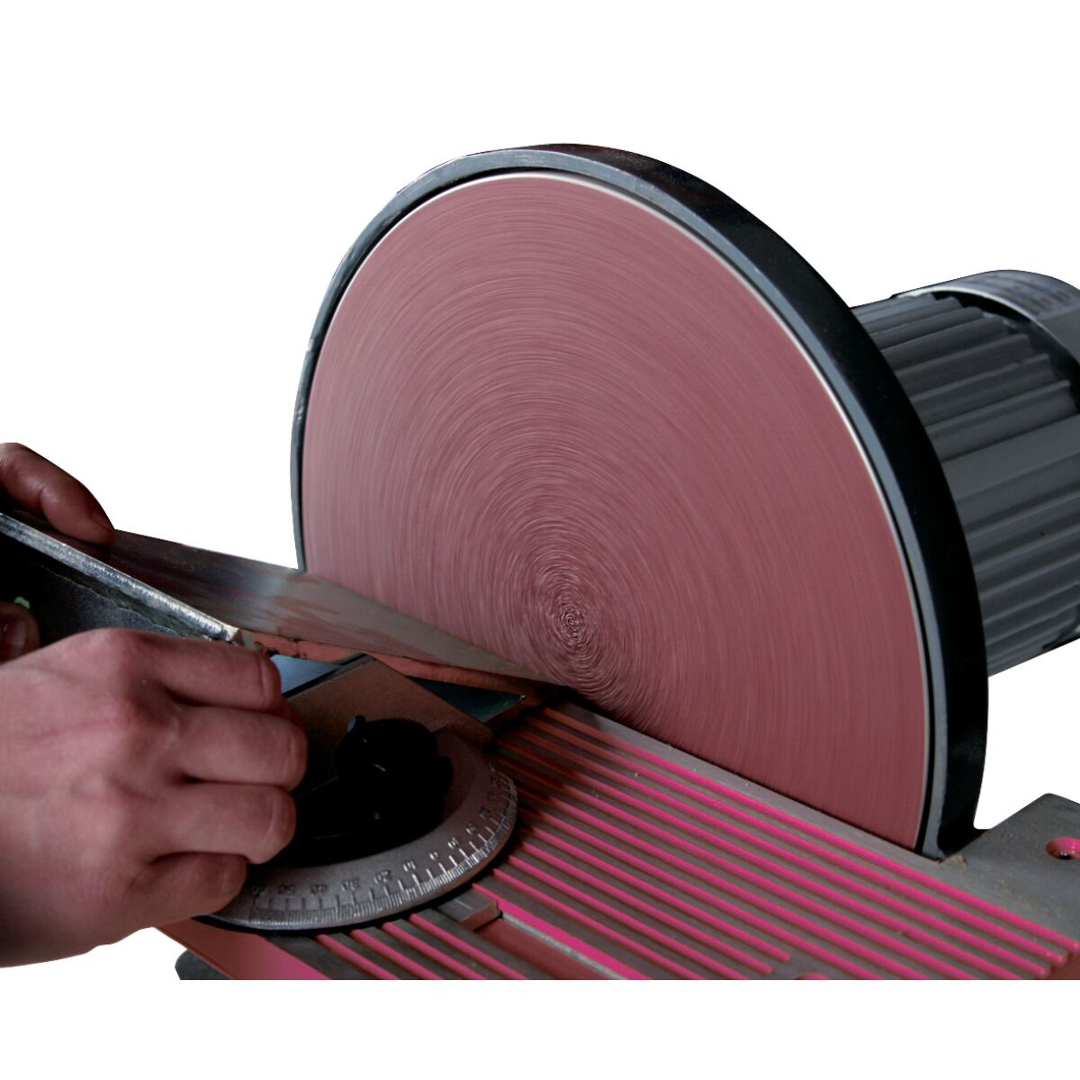 Hand führt ein Metallteil an eine rotierende Schleifscheibe auf dem verstellbaren Arbeitstisch eines Tellerschleifers.