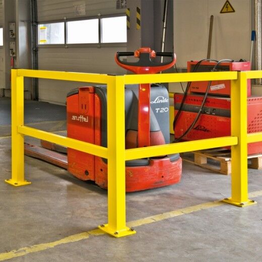 Gelbes Rammschutzgeländer umgibt ein rotes Flurförderfahrzeug in einer Lagerhalle.