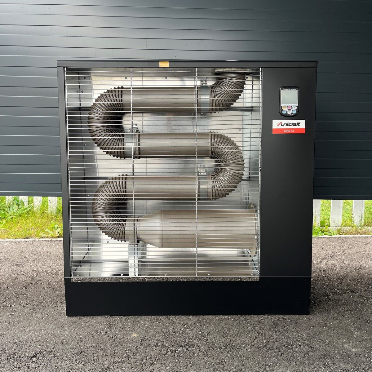 Heizgerät Unicraft IDHG 13 mit sichtbaren Metallrohren hinter Gitter.