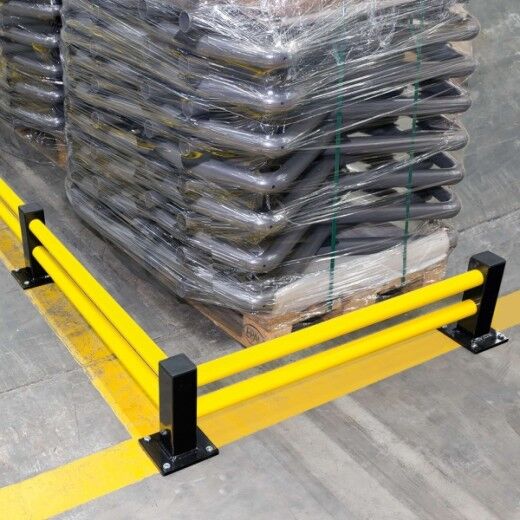 Gelb-schwarze Bodenbarriere schützt gestapelte Waren auf Palette in Lagerumgebung vor Anfahrschäden durch Fahrzeuge.